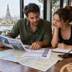 Two travellers comparing Thailand tour itineraries and costs in Bangkok
