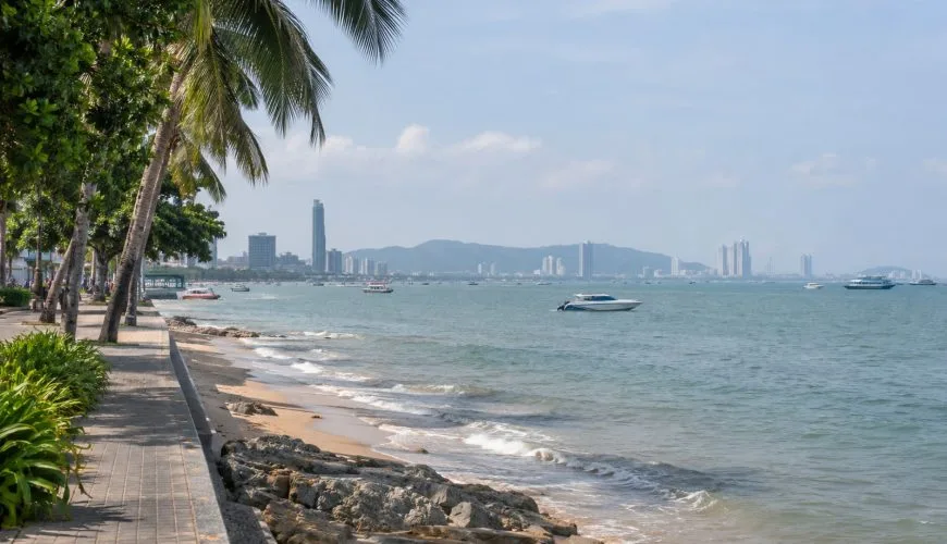 Pattaya seafront with boats and the city skyline viewed from the promenade