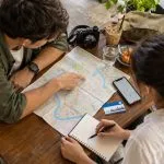 Two travellers planning a three-day Bangkok itinerary with a city map