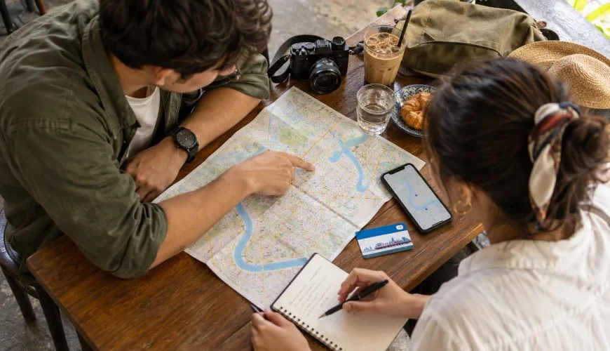 Two travellers planning a three-day Bangkok itinerary with a city map