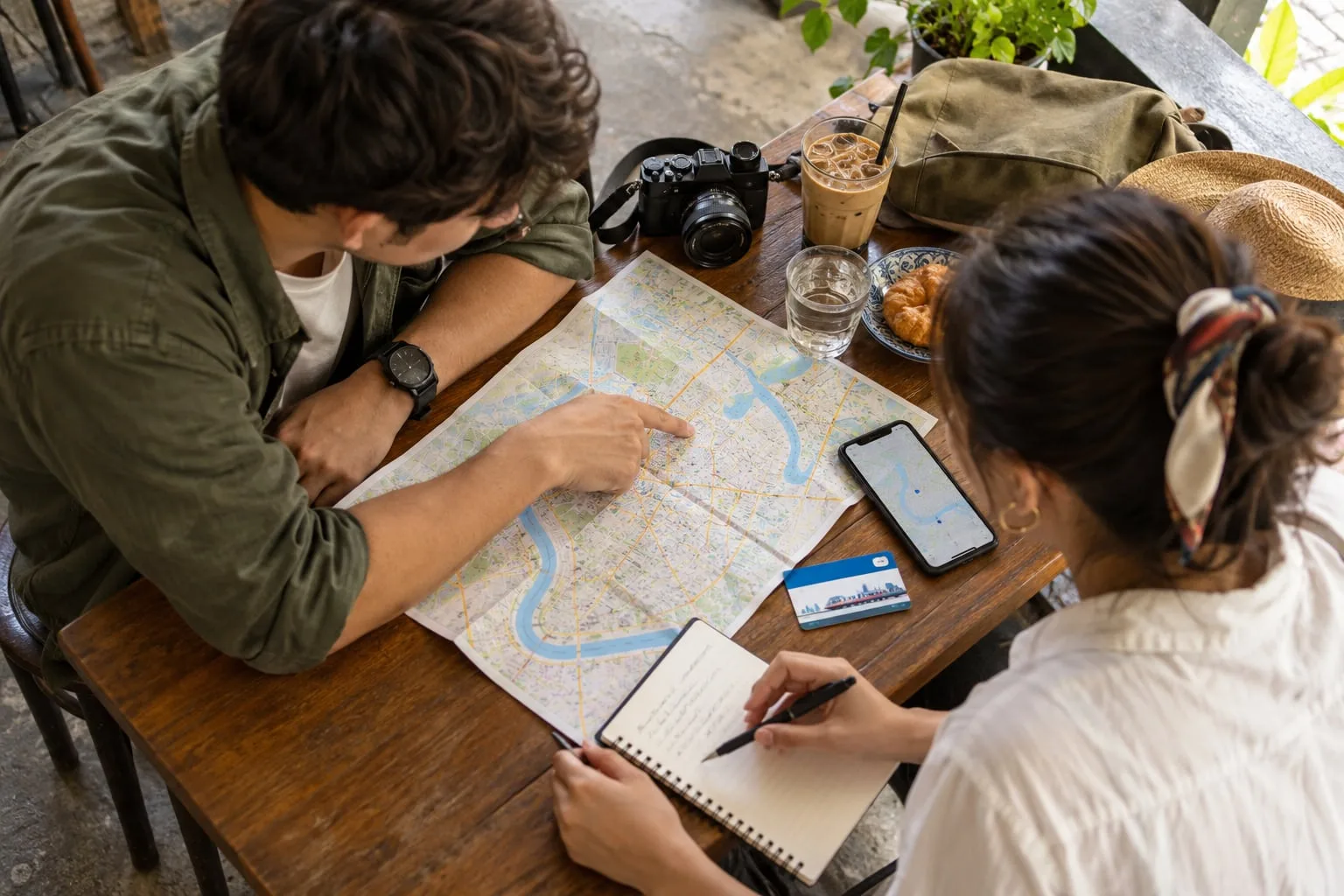 Two travellers planning a three-day Bangkok itinerary with a city map