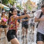 People taking part in a Songkran water celebration on a street in Thailand