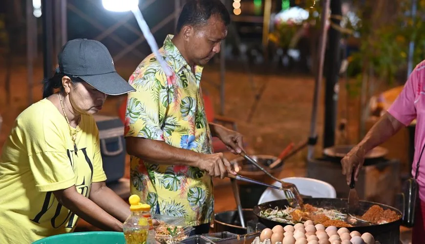 Thai cooks preparing stir-fried dishes at a Sattahip night market