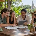 Four travellers planning a private Thailand itinerary at a cafe
