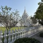 Wat Rong Khun White Temple behind ornate white railings in Chiang Rai