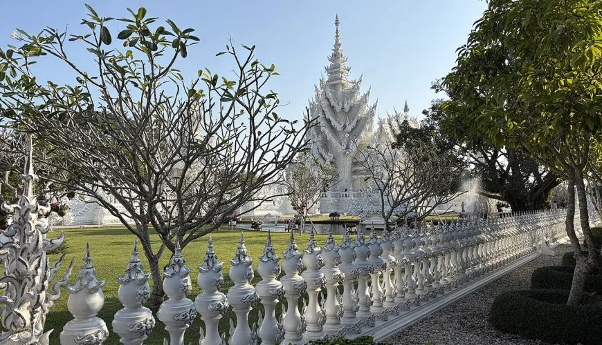Wat Rong Khun White Temple behind ornate white railings in Chiang Rai